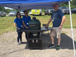 Dollar Energy Fund's Ashley Allen and Gabriella Giangiuli present the Big Green Egg to raffle winner, Ben Moore.