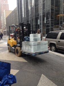 Workers deliver blocks of ice to construct a 10'X10' house in PPG Place for Dollar Energy Fund's Cool Down for Warmth fundraiser.